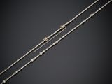 une paire de colliers en argent et en or sur fond noir