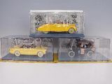 three toy cars in a display case on a table