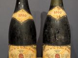 two bottles of wine sitting on top of a table next to each other