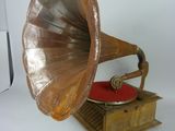 un vieux gramophone posé sur une table recouverte d'un coussin rouge