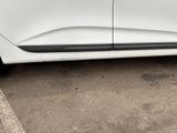 a white car parked in a parking lot next to a curb