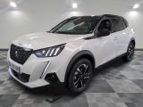 le 4x4 blanc est garé sur un sol en damier dans le garage