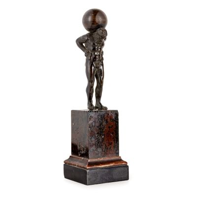 a bronze statue of a boy with a ball on his head
