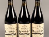 trois bouteilles de vin sont alignées sur une table