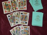Plusieurs cartes à jouer sont disposées sur un lit recouvert de feuilles de papier