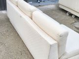 a man standing in a garage looking at a couch