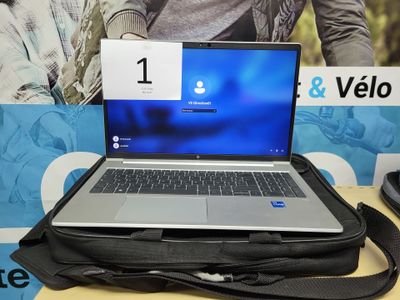 un ordinateur portable posé sur un sac, sur une table