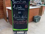a chalk board with writing on it in front of a building