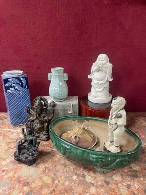 a lot of small statues on a table next to a bowl