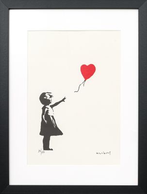 a black and white picture of a girl holding a red balloon