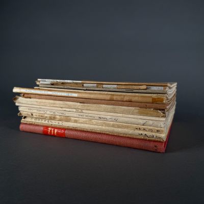 several old books stacked on top of each other on a table