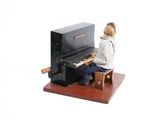 une figurine représentant une femme assise au piano
