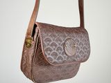 leather handbag with a circular design and a metal buckle