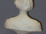 a white marble bust of a woman on a pedestal