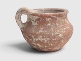 a clay pot with a handle on a white surface