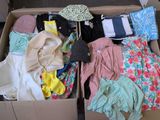 une boîte remplie de vêtements et de gants posée par terre