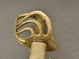 a close up of a gold colored sword with a snake on it