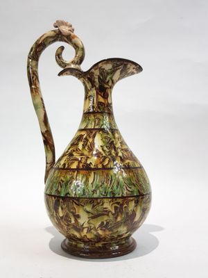 un vase marron et vert orné d'un oiseau