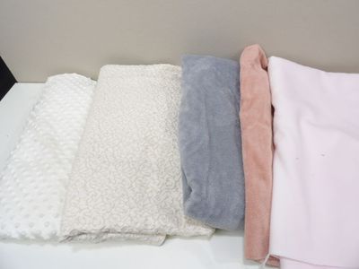 three blankets are stacked on top of each other on a table