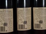 three bottles of wine are lined up on a shelf