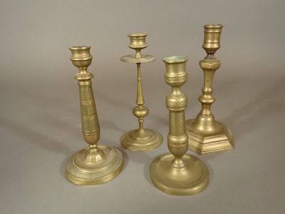 trois bougeoirs dorés sont posés sur une surface blanche