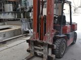 a red forklift truck parked in a warehouse