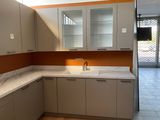 an image of a kitchen with white cabinets and a marble counter top