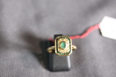 a gold ring with a green stone on it