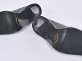 a pair of black shoes on a white surface