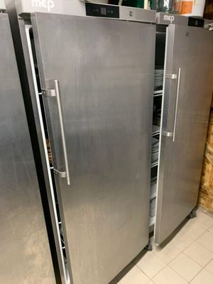deux réfrigérateurs en acier inoxydable dans une cuisine, avec un mur en briques en arrière-plan