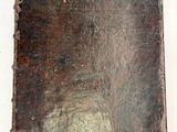 un vieux livre à la couverture marron posé sur une surface blanche