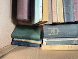 many old books stacked on top of each other in a box