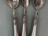 three spoons and a spoon rest on top of a table