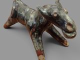 a ceramic sculpture of a bull on a gray surface