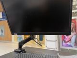 un écran d'ordinateur posé sur un bureau, avec un clavier et une souris