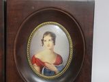 two framed pictures of a woman and a man on a table