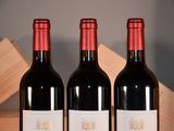 three bottles of red wine sitting on a table