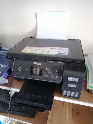 une imprimante posée sur un bureau à côté d'une imprimante