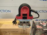 a red and black electric router sitting on top of a box