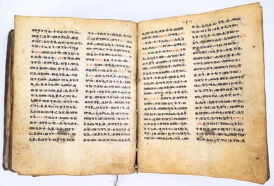 un livre ouvert, sur lequel figurent des caractères chinois, posé sur une table