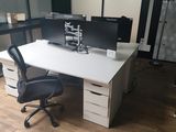 une photo d'un bureau avec deux écrans et une chaise