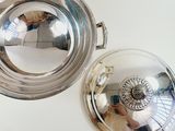 a silver plate with a lid on a white table