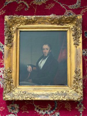 painting of a man in a suit and tie sitting in a gold frame on a red carpet