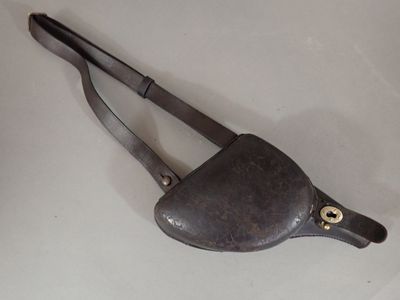 un sac à main en cuir muni d'une poignée en métal, sur un fond blanc