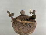 a statue of a frog sitting on top of a clock