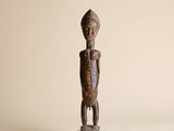 une statue en bois d'un homme avec un chapeau sur la tête