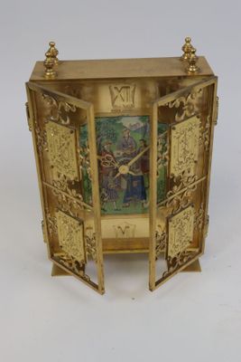 une horloge en or sur laquelle est représenté un homme et une femme