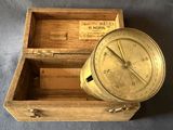 une vieille boussole en laiton dans un coffret en bois sur fond bleu