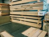 un homme qui se tient debout devant un tas de bois