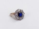 a close up of a blue and white diamond ring on a white surface